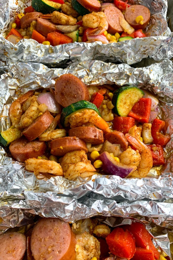 Close up of cajun shrimp foil packets on a baking sheet.