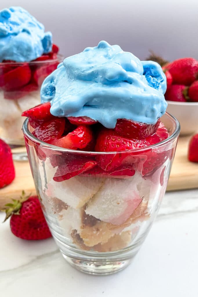 patriotic strawberry shortcake in a serving glass with blue whip cream