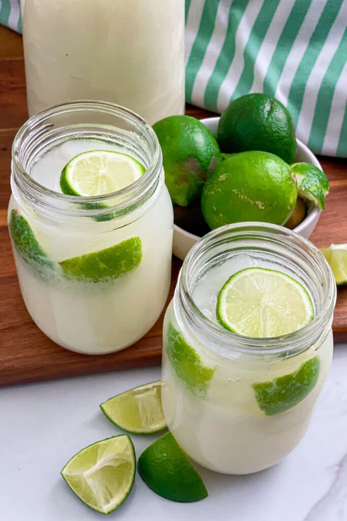 Brazilian Lemonade in serving glasses with lime wedges on the side