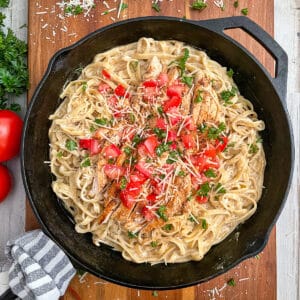 the most amazing Cajun chicken alfredo recipe served with diced tomatoes and chopped parsley