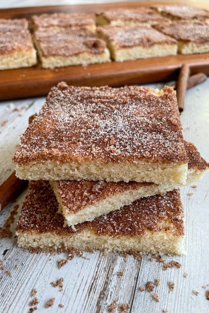 The best soft and chewy snickerdoodle cookie bars stacked on top of each other