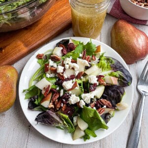 Autumn Pear salad with honey mustard dressing served on a white plate