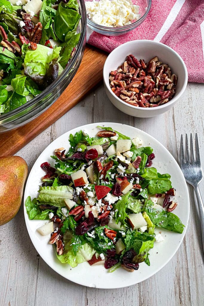 The best Autumn pear salad with honey mustard dressing served on a white plate