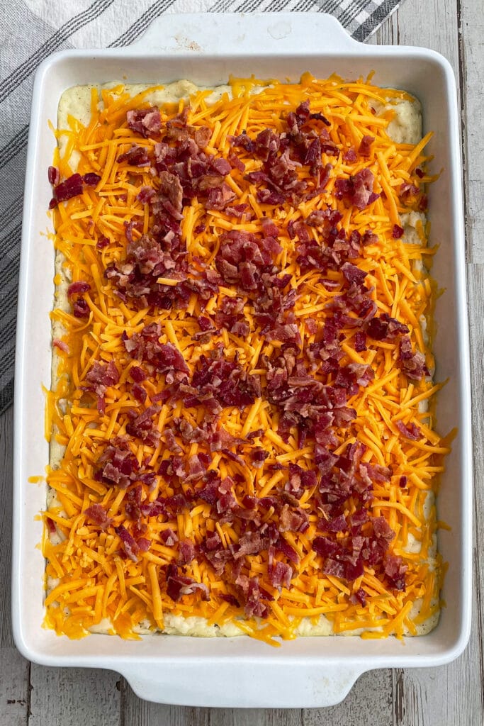 potato casserole topped with shredded cheese and bacon