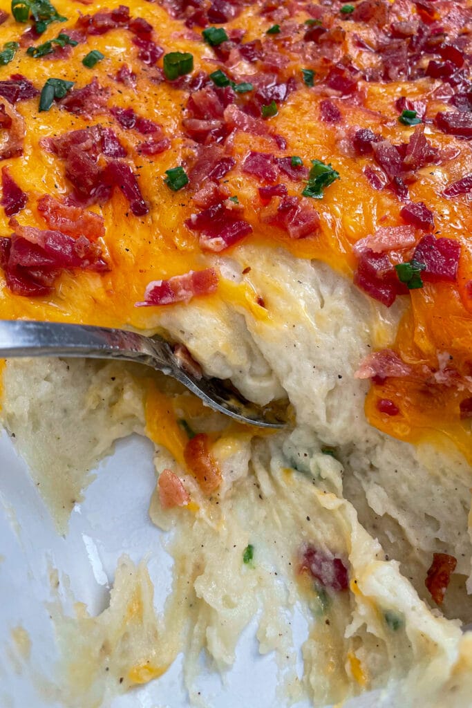 loaded mashed potato casserole topped with bacon, cheese, and green onions