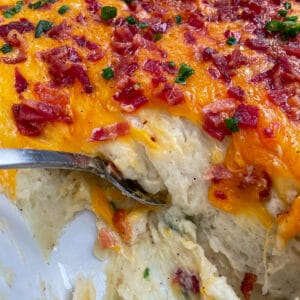 loaded mashed potato casserole with a spoon for serving