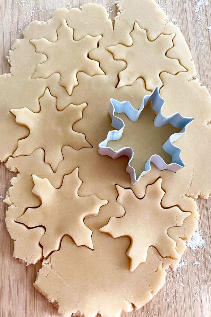 Sugar cookie dough rolled out with cookie cutters