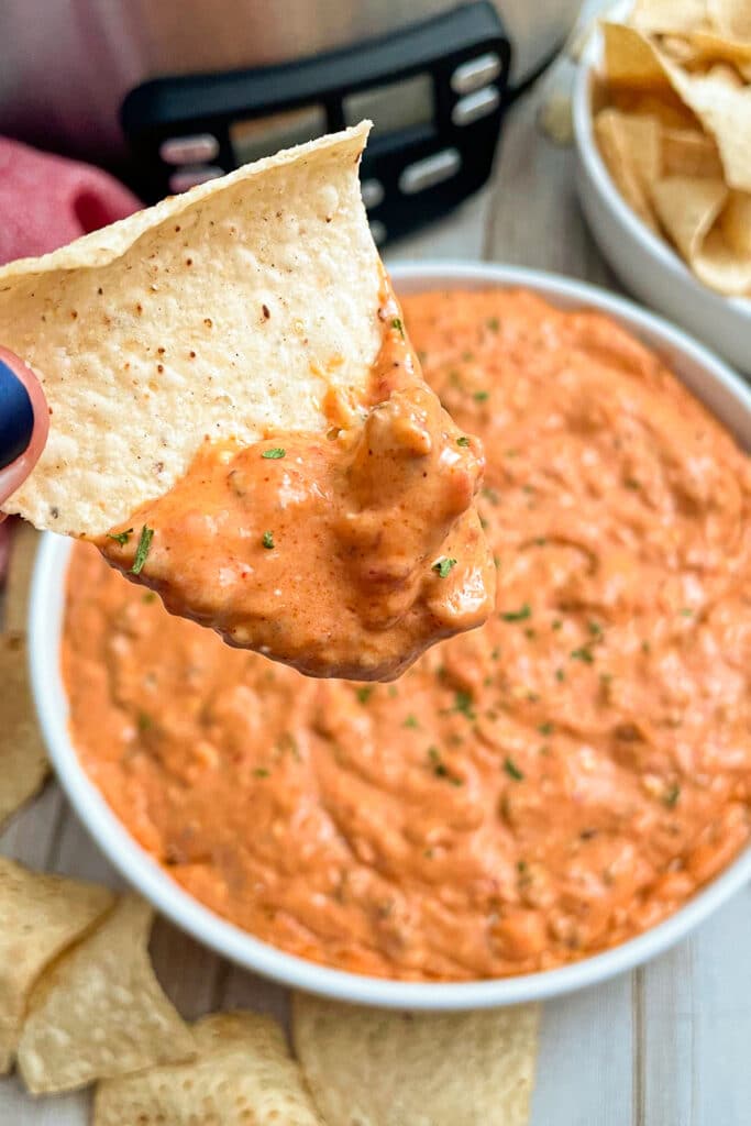 Easy cream cheese taco dip served in a white bowl and chips for serving