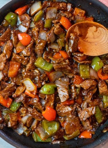 Chinese pepper steak recipe with thinly sliced steak, red and green bell peppers in a savory sauce.