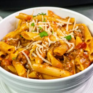 Close up of crock pot penne pasta in a white bowl.