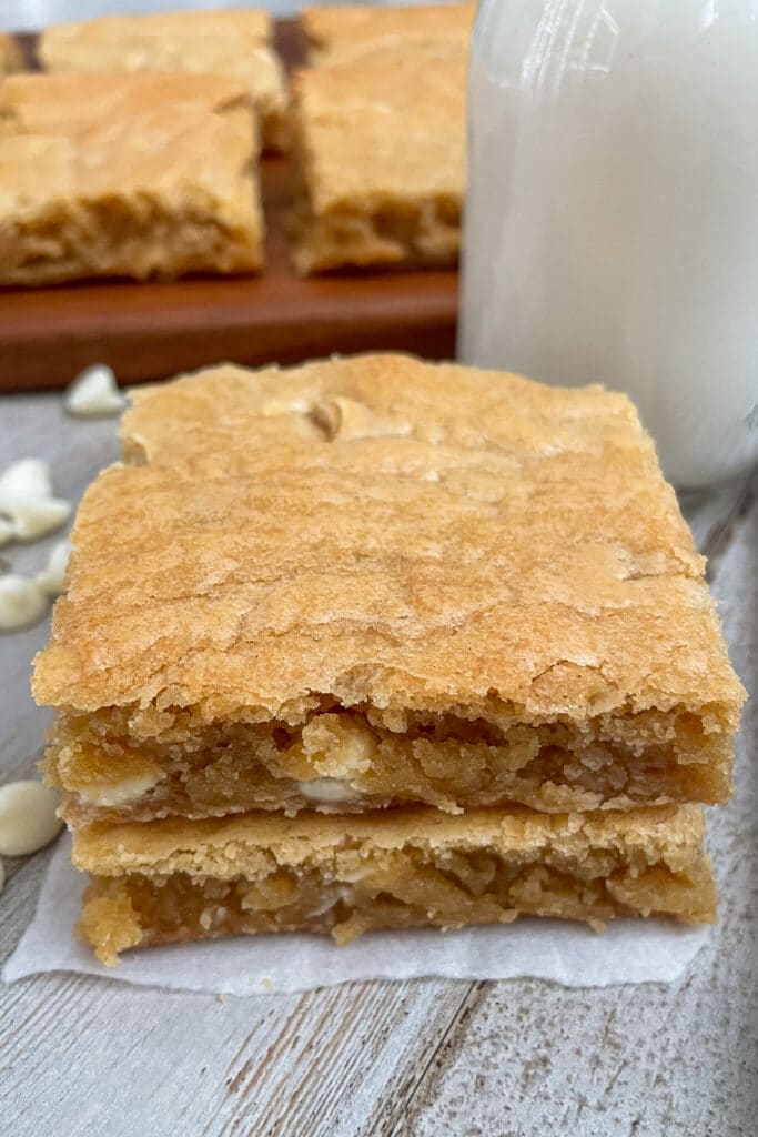 blondies stacked on top of each other with a glass of milk