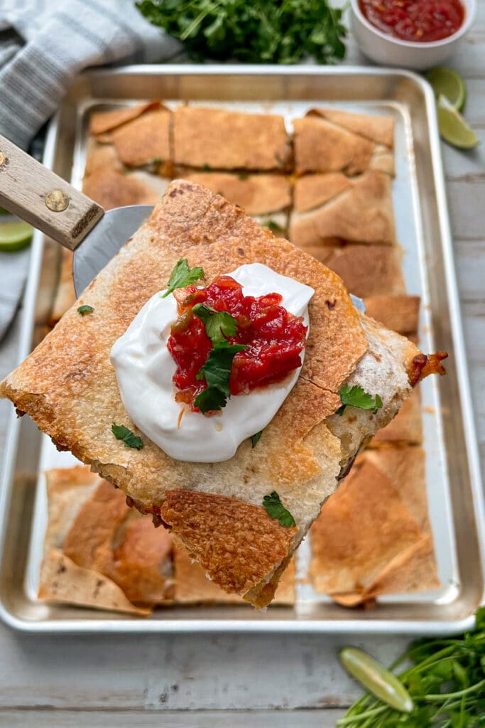 sheet pan quesadillas with ground beef served with limes and salsa