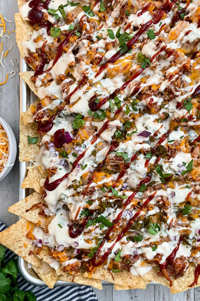 oven baked BBQ chicken nachos drizzled with BBQ sauce