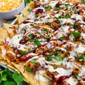 close up shot of BBQ chicken nachos baked on a sheet pan