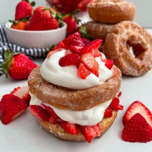 Close up shot of strawberry shortcake donut with strawberries on the side