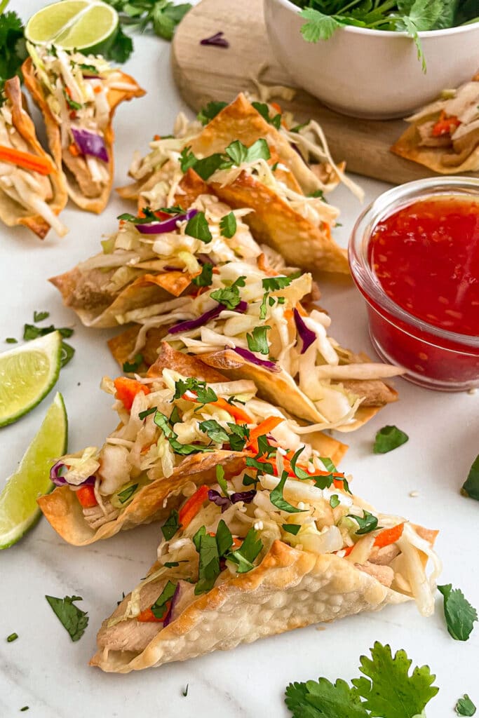 Applebee's crispy chicken wonton tacos with lime wedges, chili sauce, and cilantro