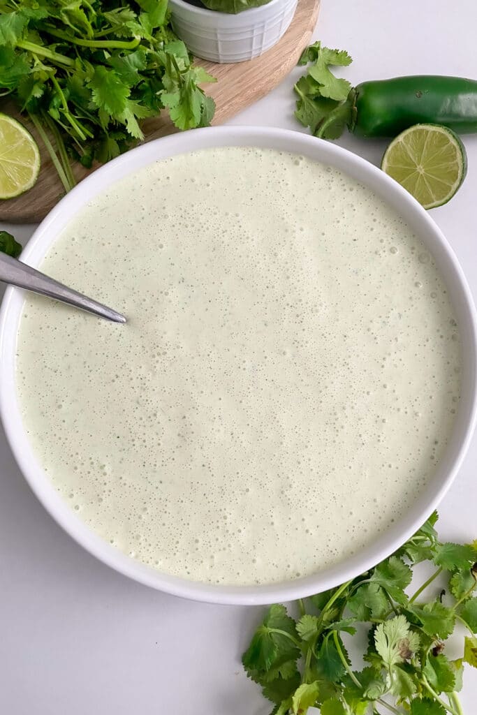Copycat Cafe Rio Tomatillo Dressing in a large serving bowl with a spoon