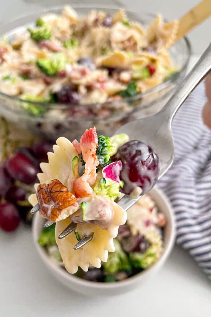 close up photo of broccoli grape salad on a fork