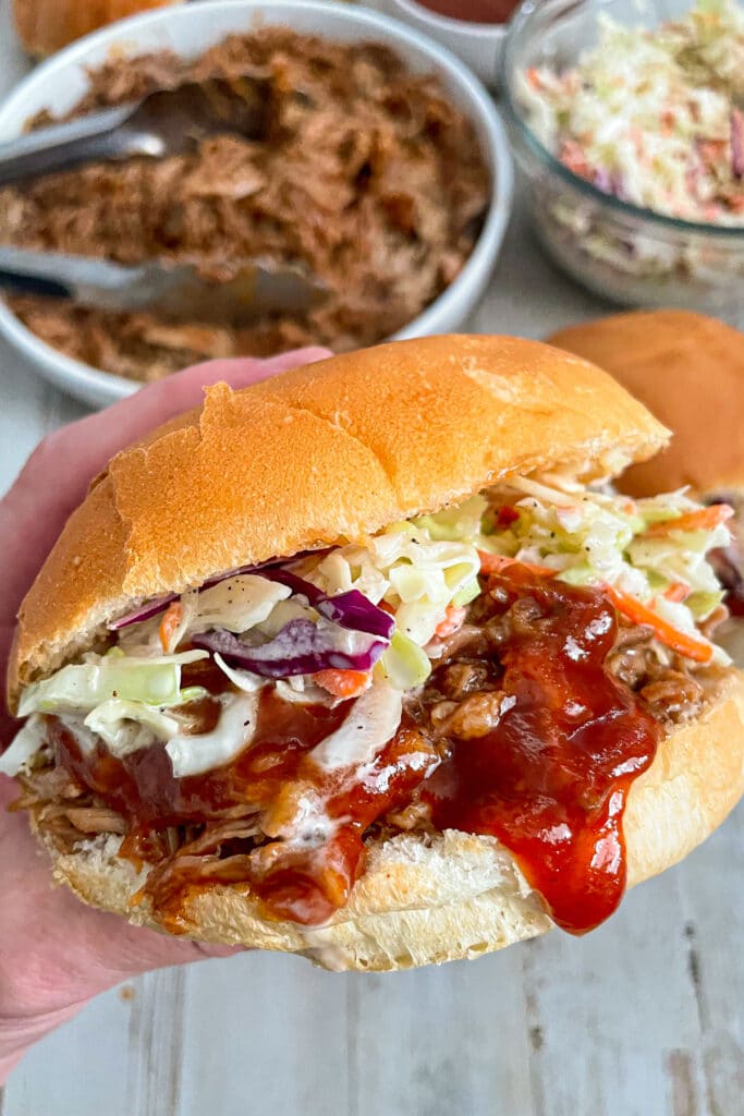 slow cooker pulled pork served on a bun with coleslaw