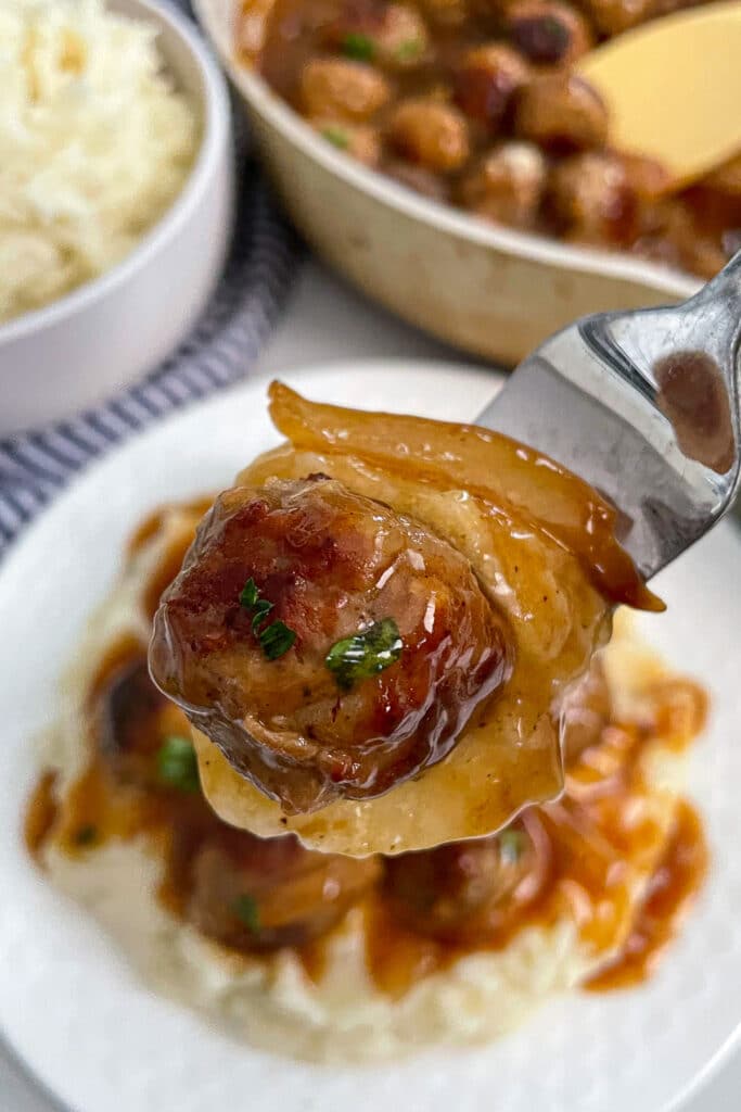 close up shot of salisbury steak meatballs on a fork