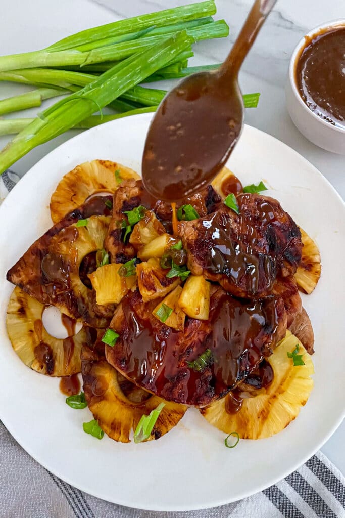 easy grilled pork chops on a plate with pineapple slices