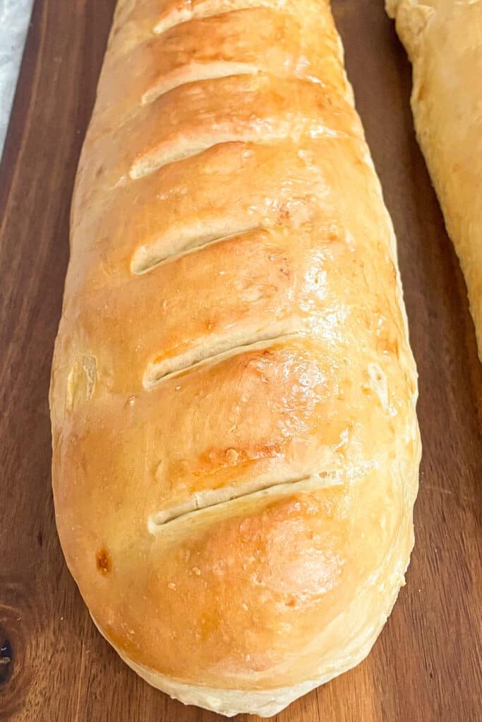 close up photo of a loaf of baked French bread on a cutting board