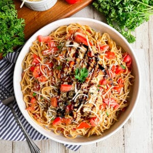 Best Bruschetta pasta in a white serving bowl topped with balsamic glaze
