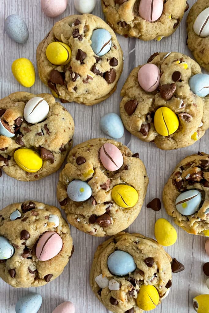 half a dozen cadbury egg cookie laid flat with mini cadbury eggs next to the cookies
