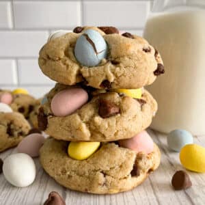 The best Cadbury egg cookies stacked on top of each other. Milk in the background