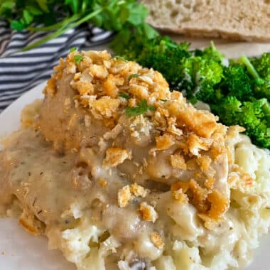 slow cooker ritz chicken on a white serving plate with mashed potatoes and broccoli on the side