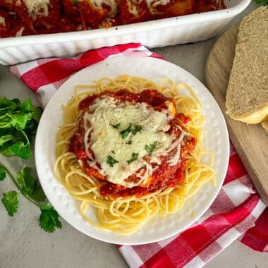 The easiest parmesan chicken recipe on a serving plate with pasta noodles