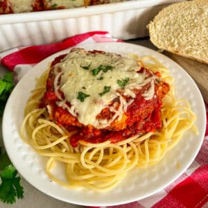 The easiest parmesan chicken recipe on a serving plate with pasta noodles