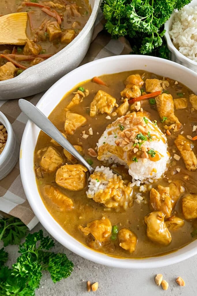 image of bang bang chicken in a large white serving bowl with a spoon that has taken a bite out of the rice.