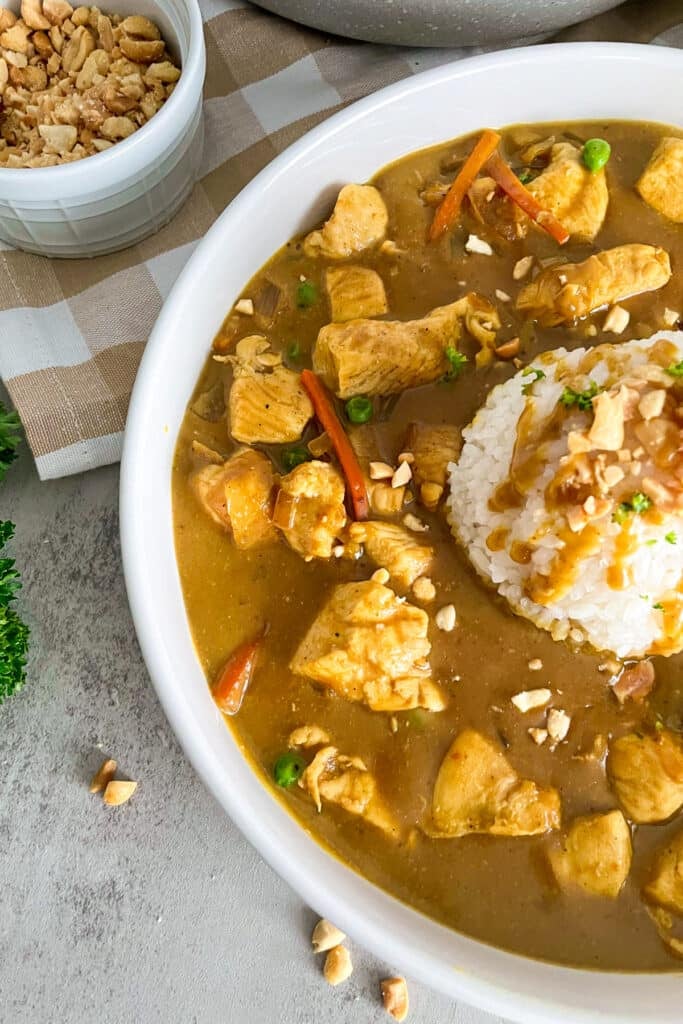 close up photo of cheesecake factory bang bang chicken in a white serving bowl with a scoop of rice in the middle