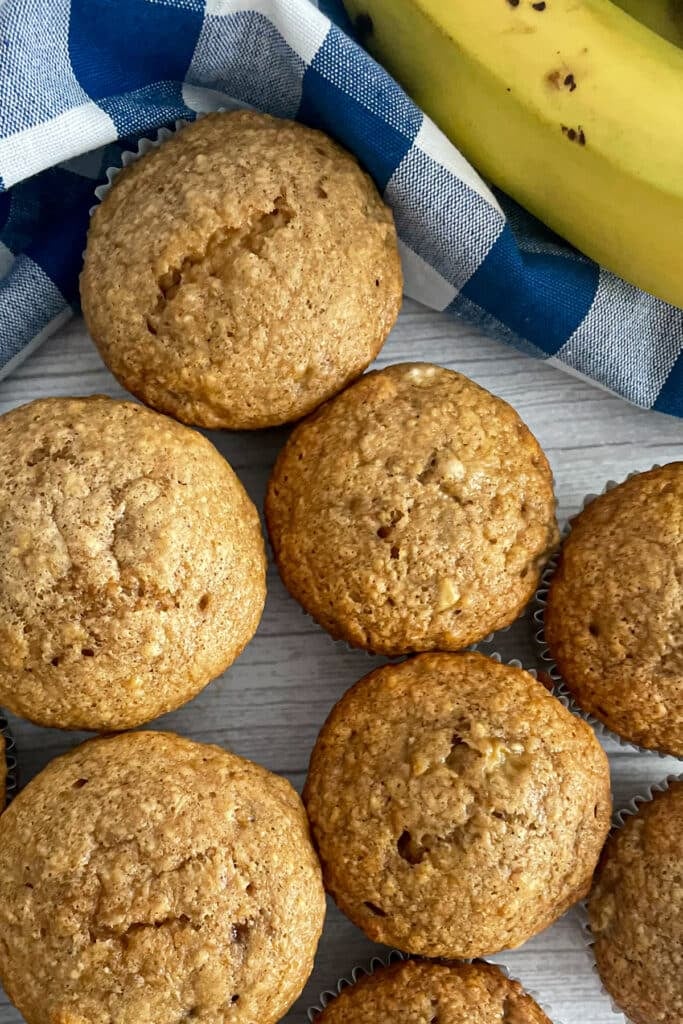 banana muffins on a serving tray with a banana in the top right corner