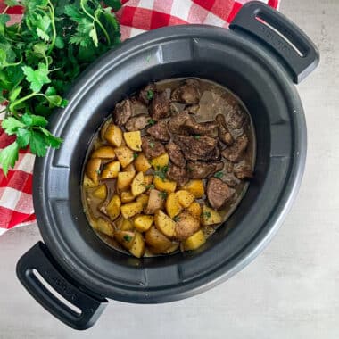 slow cooker garlic butter steak and potatoes in a crock pot before serving