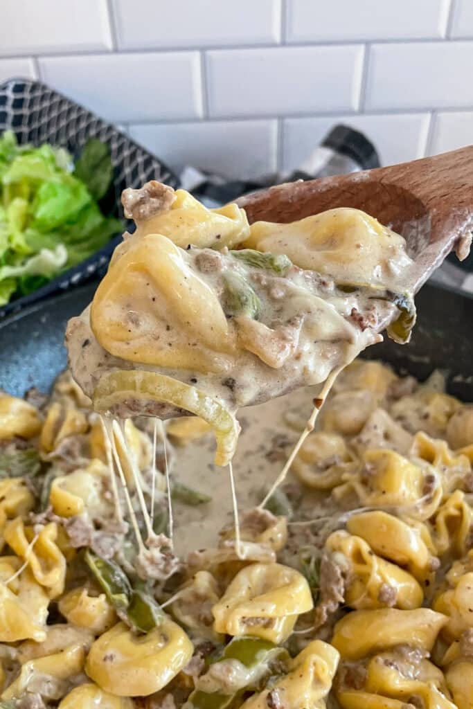 close up shot of one pan tortellini on a wooden spoonfor serving