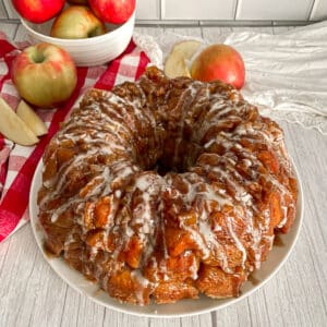 Apple Fritter Monkey Bread ready to serve. Apples shown in the background
