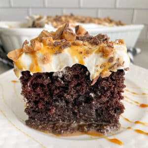 one slice of better than sex cake on a white serving plate.