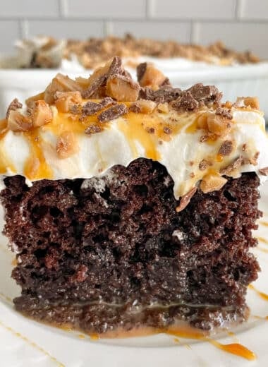 one slice of better than sex cake on a white serving plate.