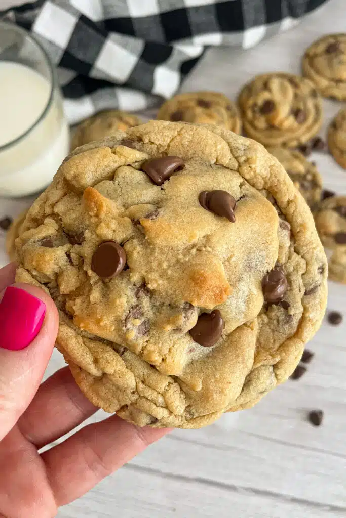 Copycat Crumbl chocolate chip cookie being held up in a hand to show the size