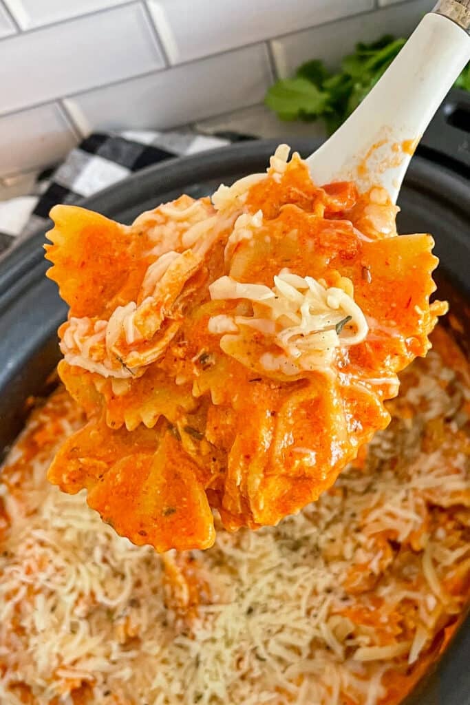 close up photo of a large spoon full of Italian chicken pasta for serving.