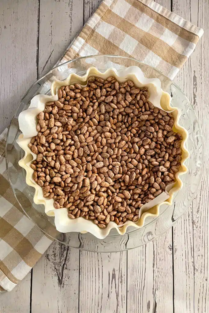 Blind baking pie crust with dried beans to keep shape