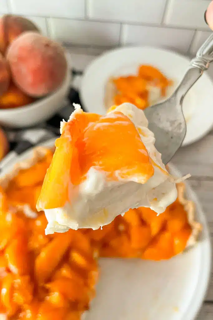 close up of a bite on a fork to show the creamy texture and the fresh peaches on top of every bite