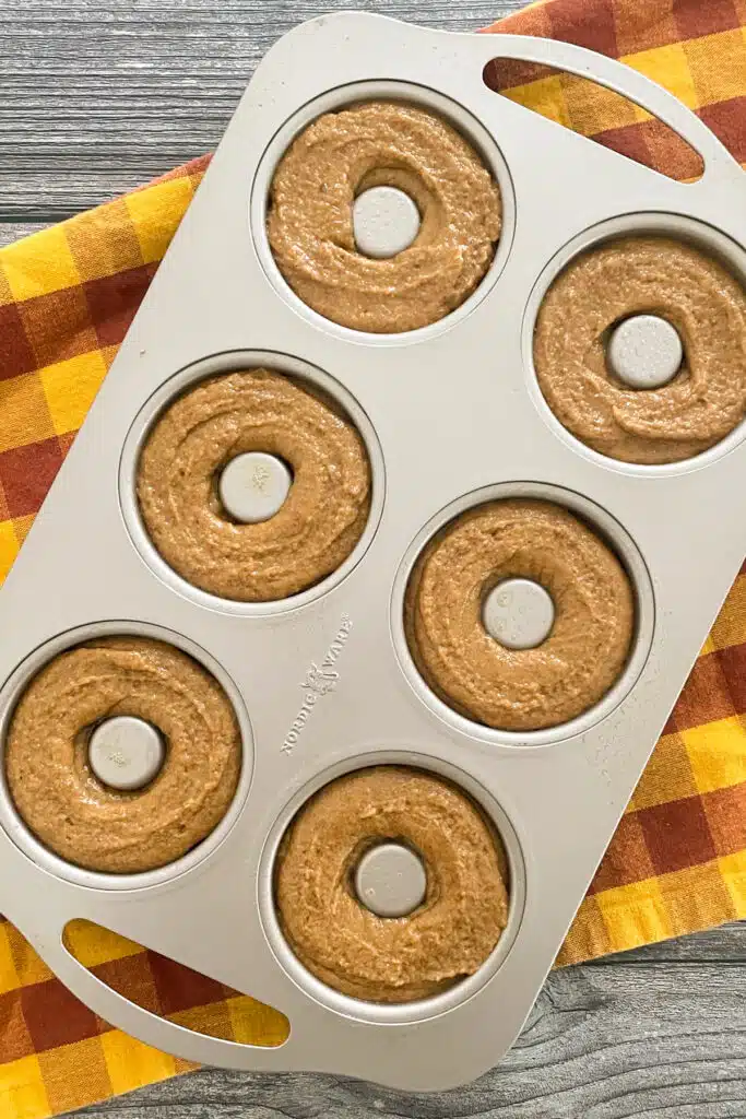 صورة لعجينة دونات اليقطين التي يتم وضعها في قالب دونات قبل الخبز. 