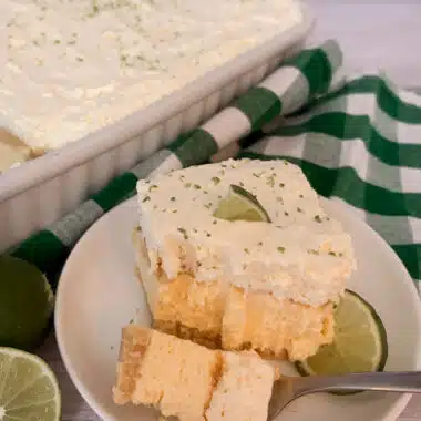 slice of no-bake key lime pie with a bite taken out of it with a fork to show the layers of the dessert