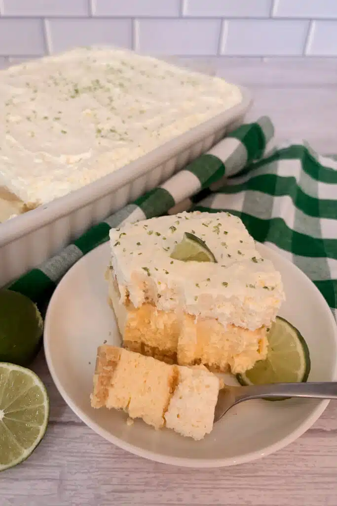 slice of no-bake key lime pie with a bite taken out of it with a fork to show the layers of the dessert